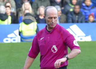 Mike Dean looks at his watch as he adds five extra minutes onto a Premier League game when he should only have added three.