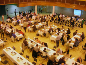 People playing chess in large auditorium 