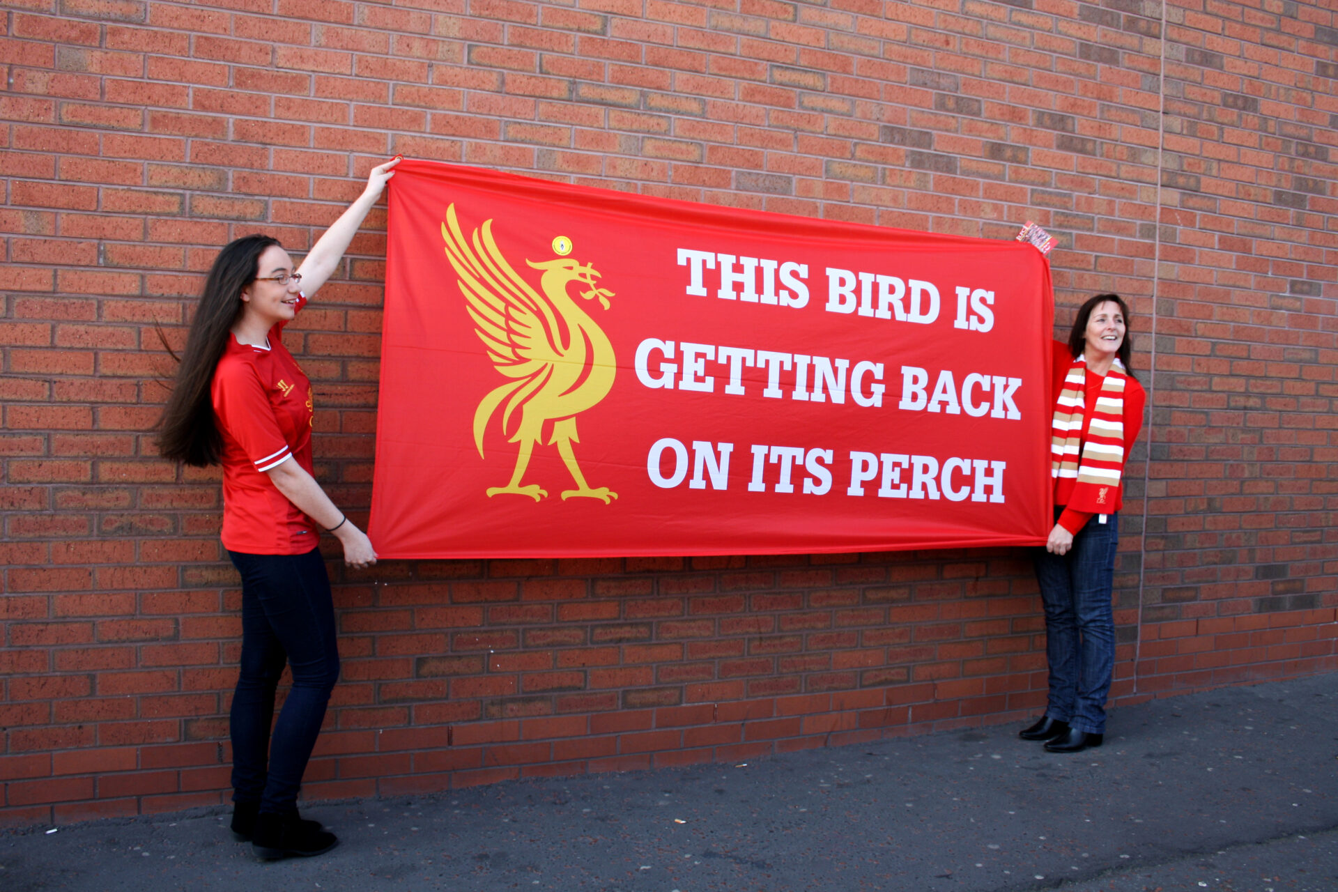 Two Liverpool fans hold a banner