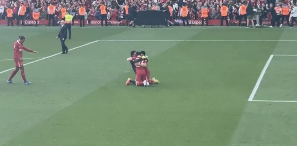 Alisson, Wataru Endo and Andrew Robertson hug after winning the Premier League by Daniel Moffat