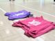 Bibs lined up on a netball court. Image taken by Sienna Hughes.